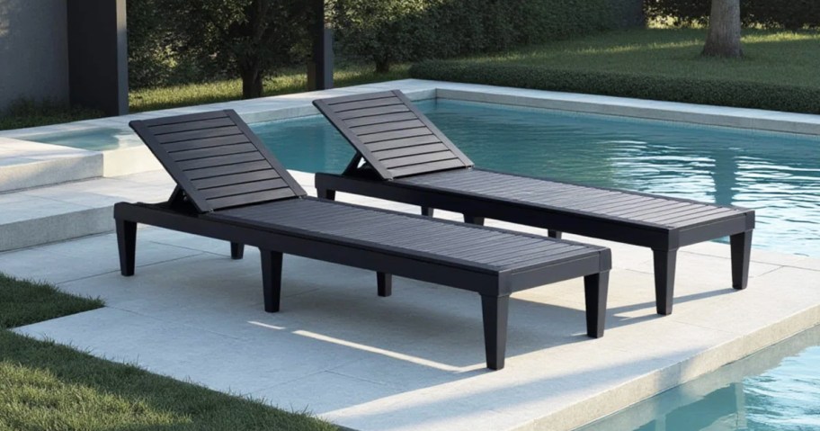 two black chaise lounge chairs by pool