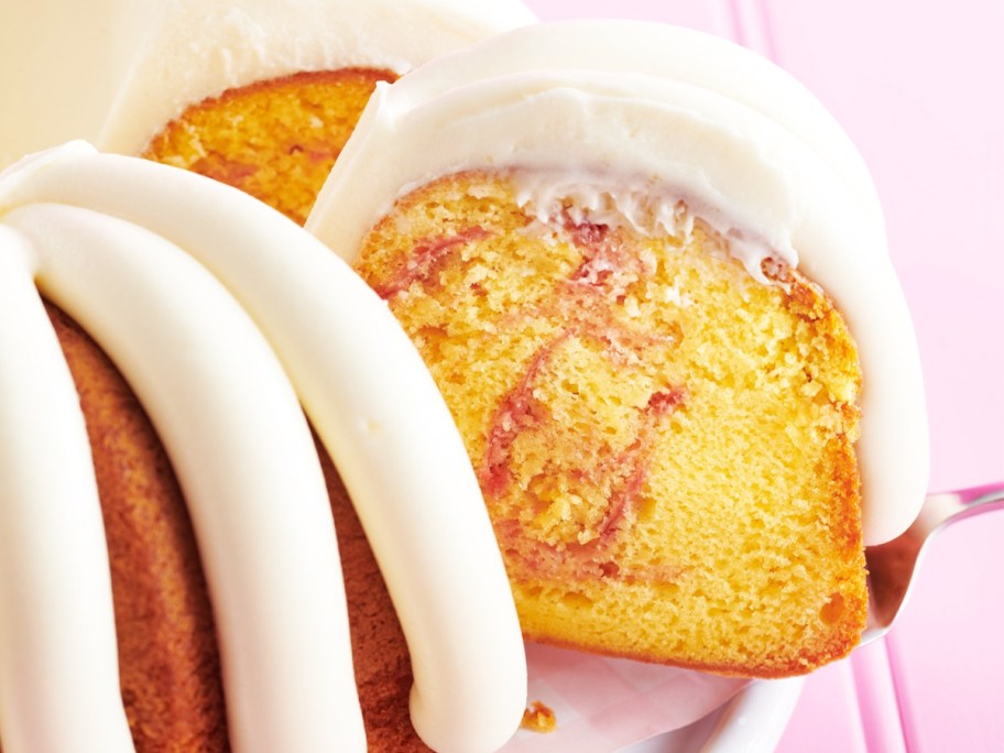 cutting a slice of a lemon raspberry bundt cake