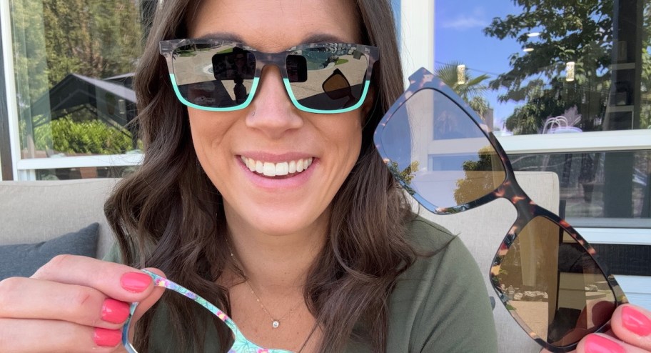 woman wearing sunglasses holding eye glasses