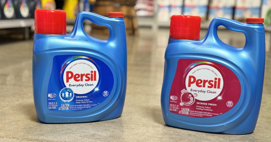 two large blue bottles of Persil laundry detergent on floor of store