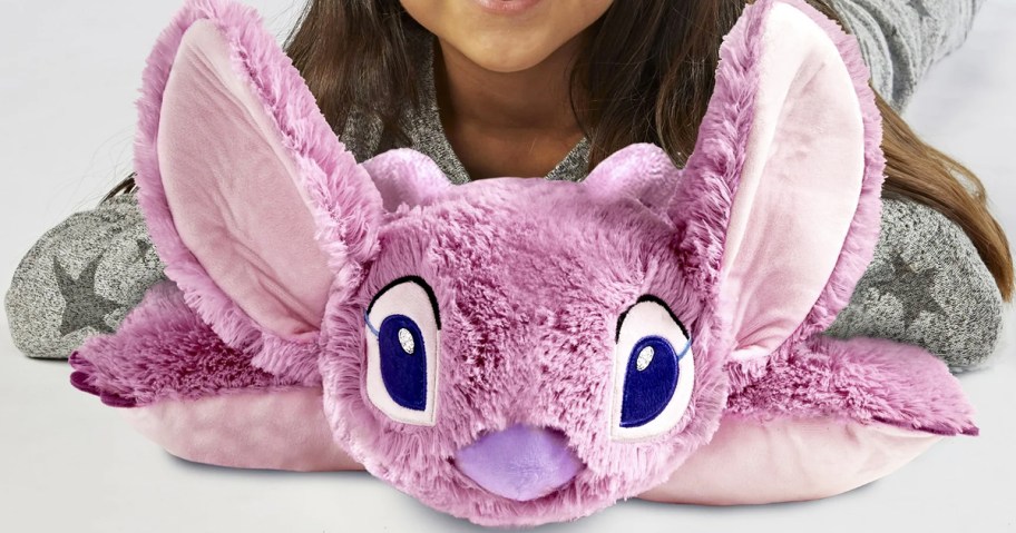 girl laying on a purple pillow pet on angel from lilo & stitch