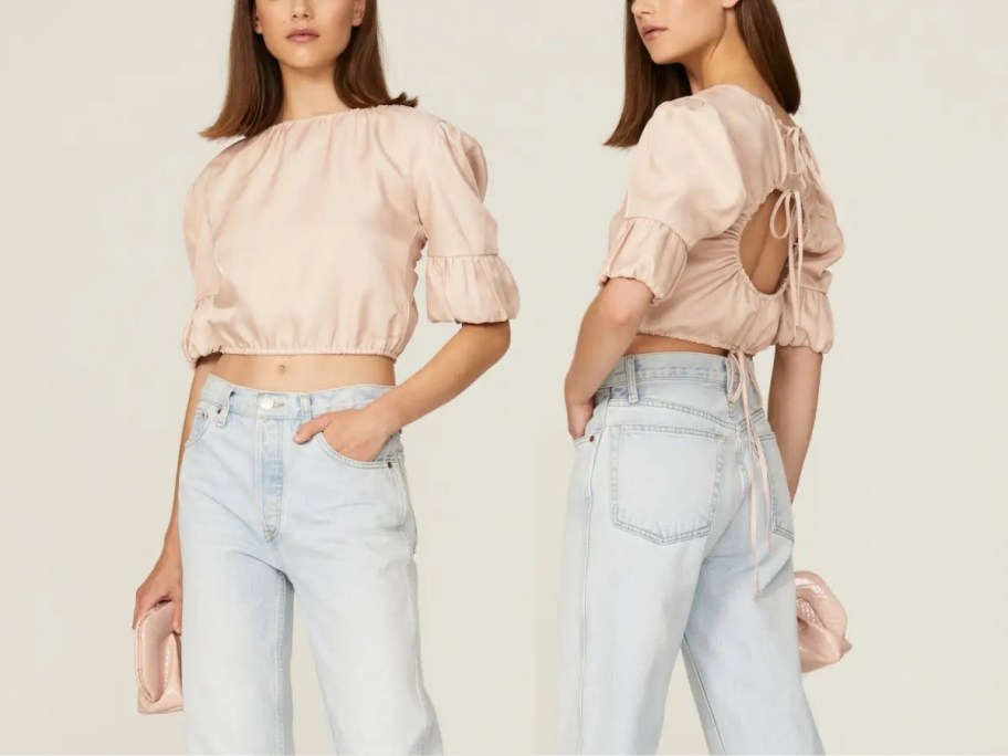 a woman in a pale pink cropped openback shortsleeve top