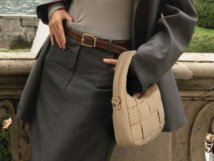 woman in a grey outfit with a tan puffer bag