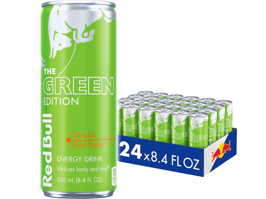 large can of Red Bull Green Edition in front of case of more cans