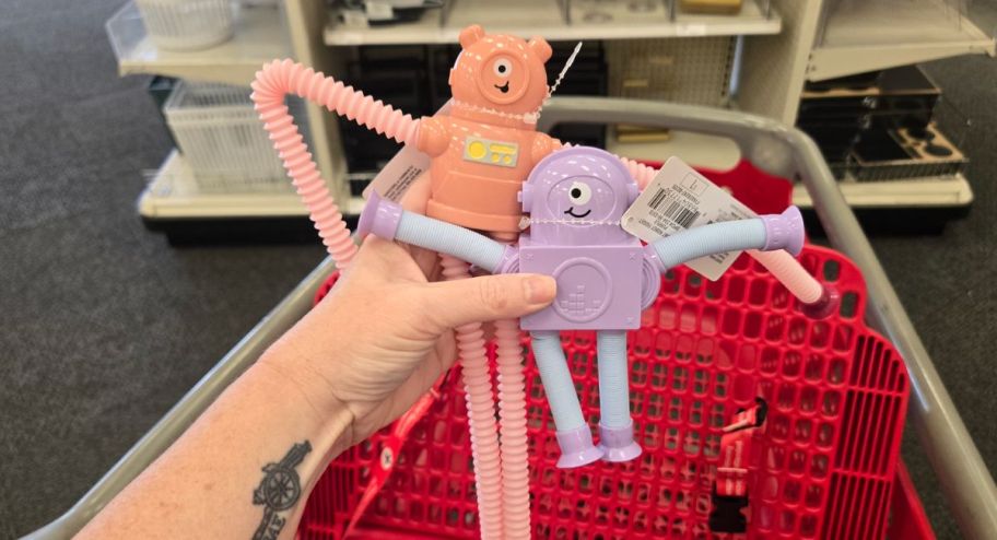 hand holding Robot Fidget Toy in front of a target shopping cart