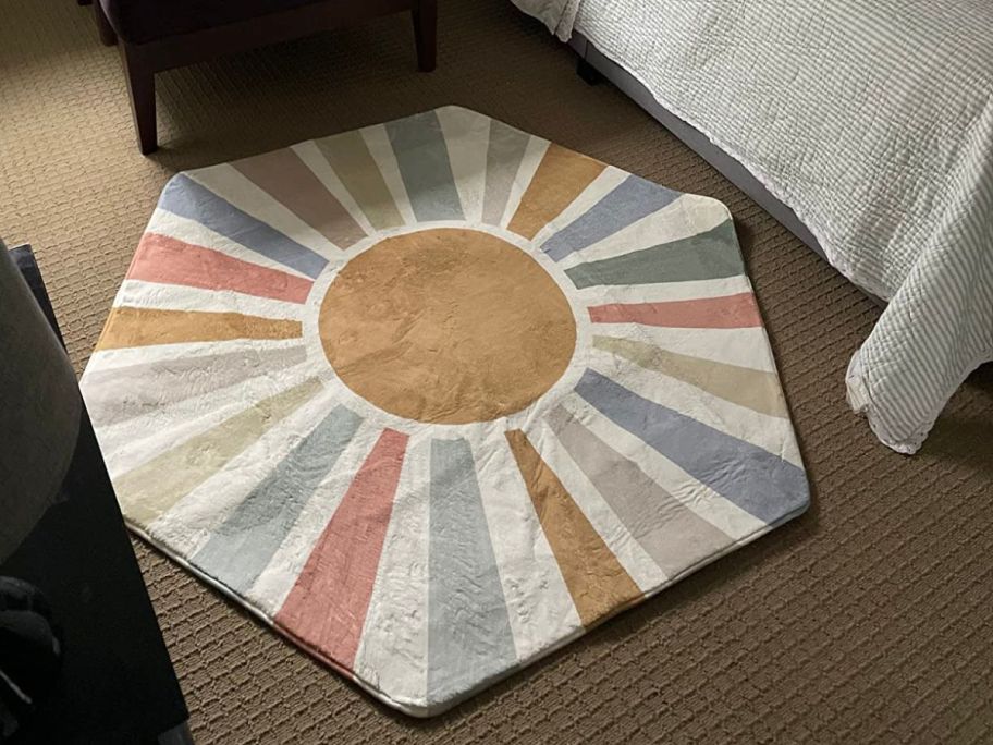 A rug with a sun on it in the middle of a bedroom 