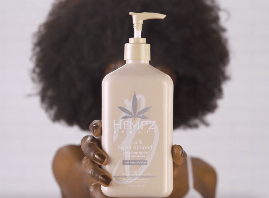 hand holding a bottle of Hempz lotion