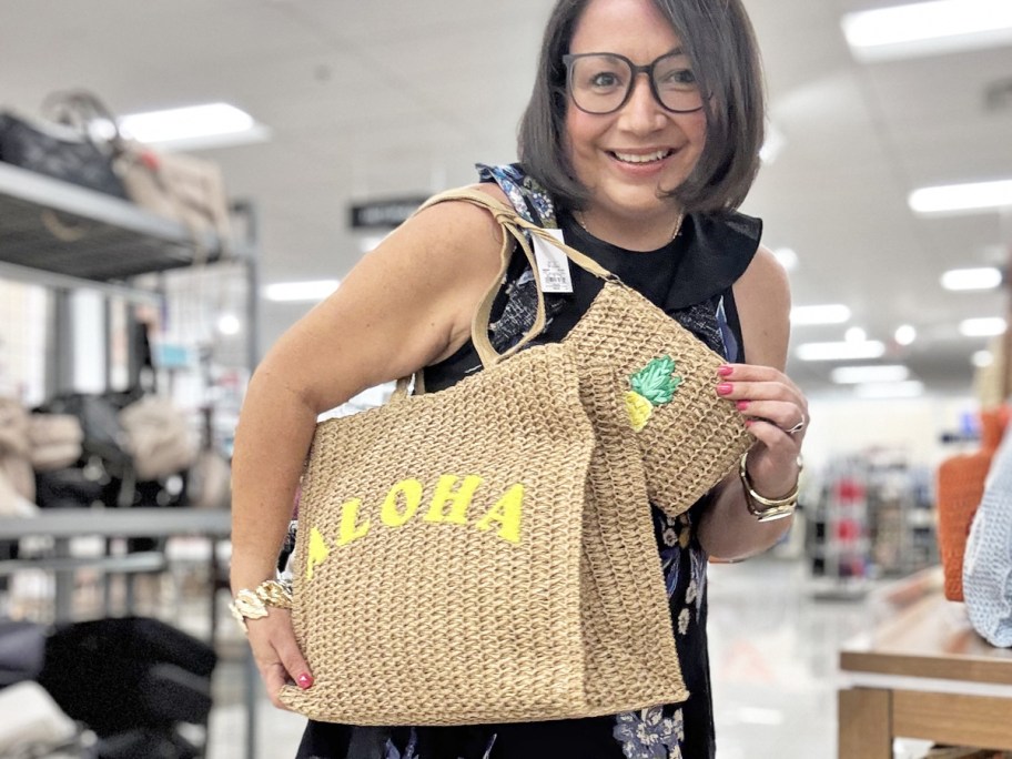 woman with a straw tote that says "aloha" with matching pineapple wristlet