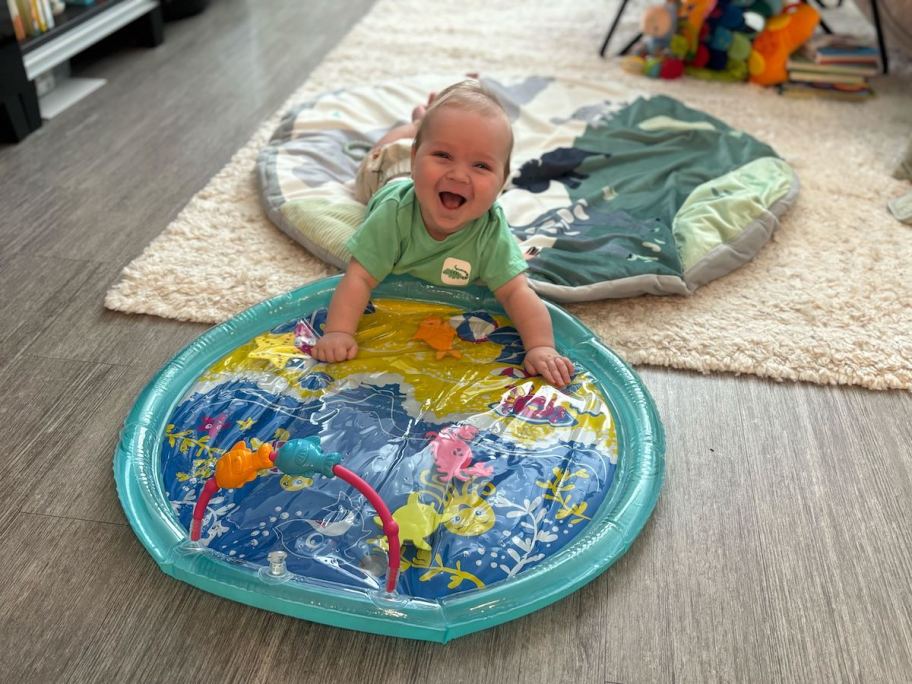 baby laughing on belly with water play mat