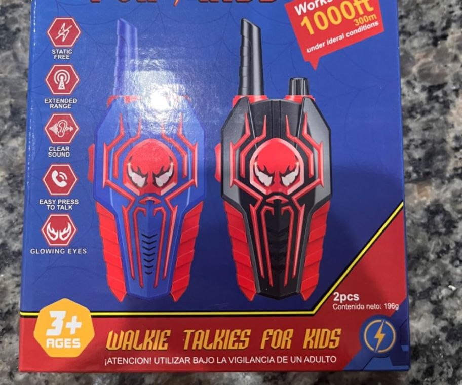 Two kids walkie talkies with Spiderman-like logo on them in a box