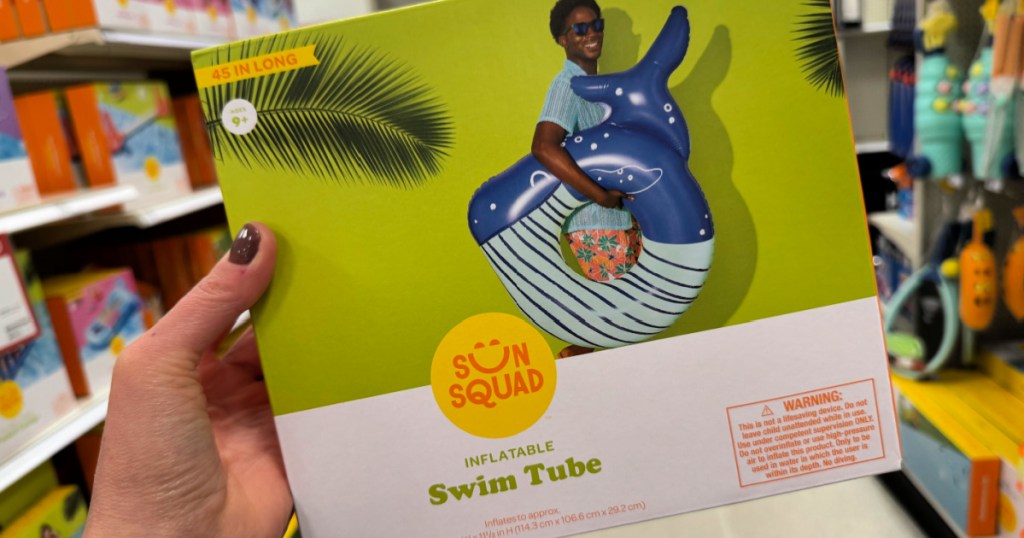 Person holding up sun squad whale tube inside target store
