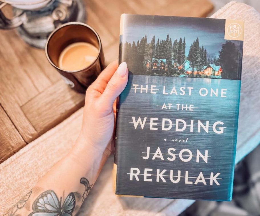 hand holding The Last One at the Wedding book
