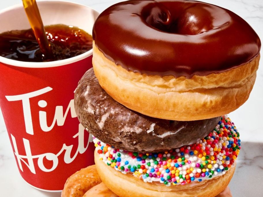 A Tim Horton's Coffee next to a stack of Tim Horton's Donuts