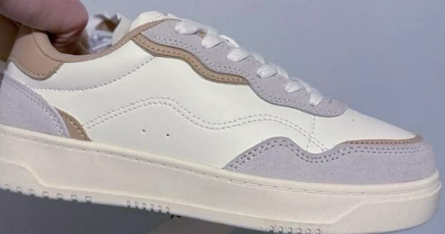 Time & Tru Sneakers from Walmart being held