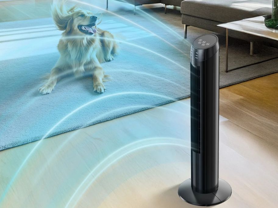 A tower fan with a dog nearby enjoying the breeze