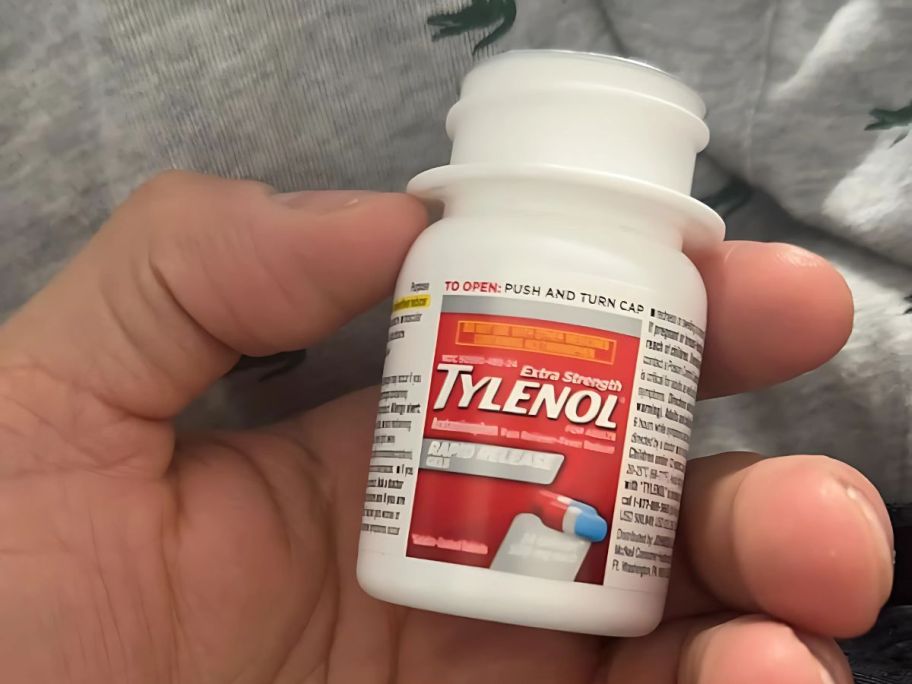 A small Tylenol bottle in someone's hand