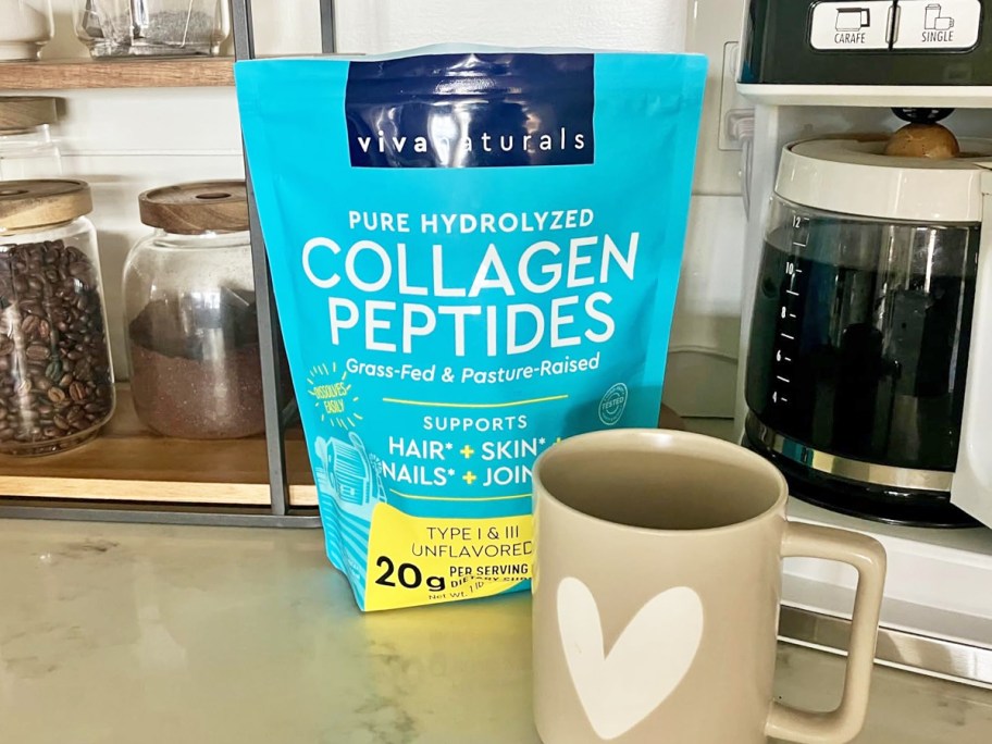 blue bag of Viva Naturals Hydrolyzed Collagen Peptides near coffee mug and coffee maker on kitchen counter