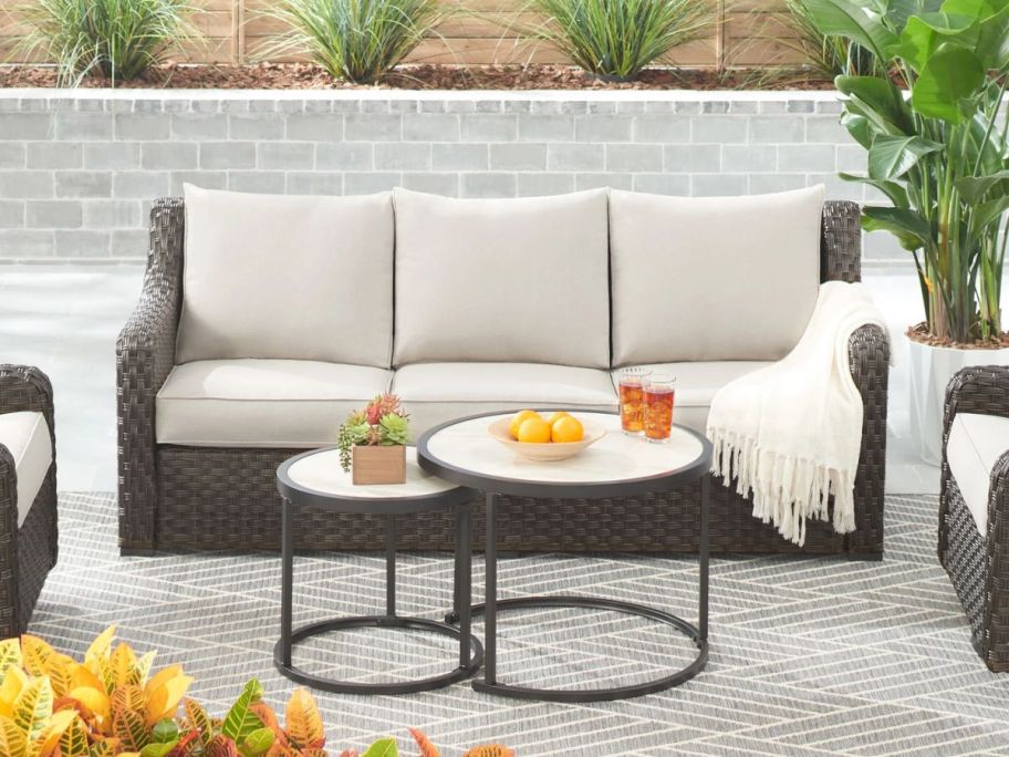 A patio with a Better Homes & Gardens River Oaks Outdoor Sofa w/ 2 Nesting Tables 