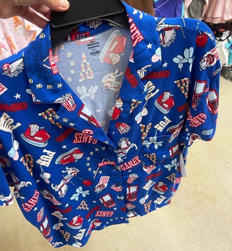 hand holding up a set of blue, white, and red carnival print pajamas