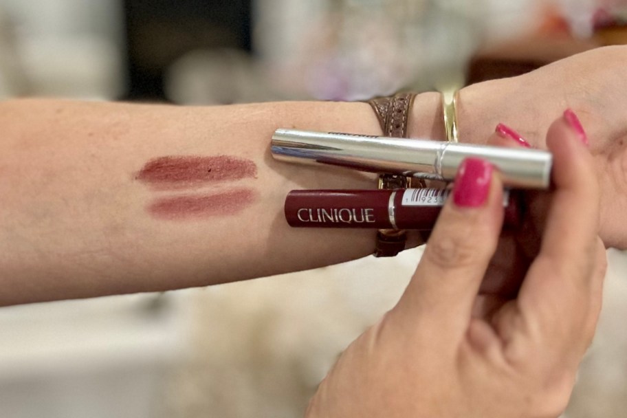 two deep eggplant lipsticks on forearm