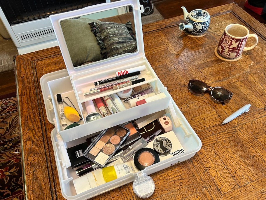 caboodle filled with makeup on wood table