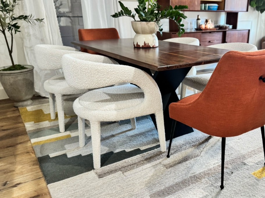 white boucle dining chair next to orange chair
