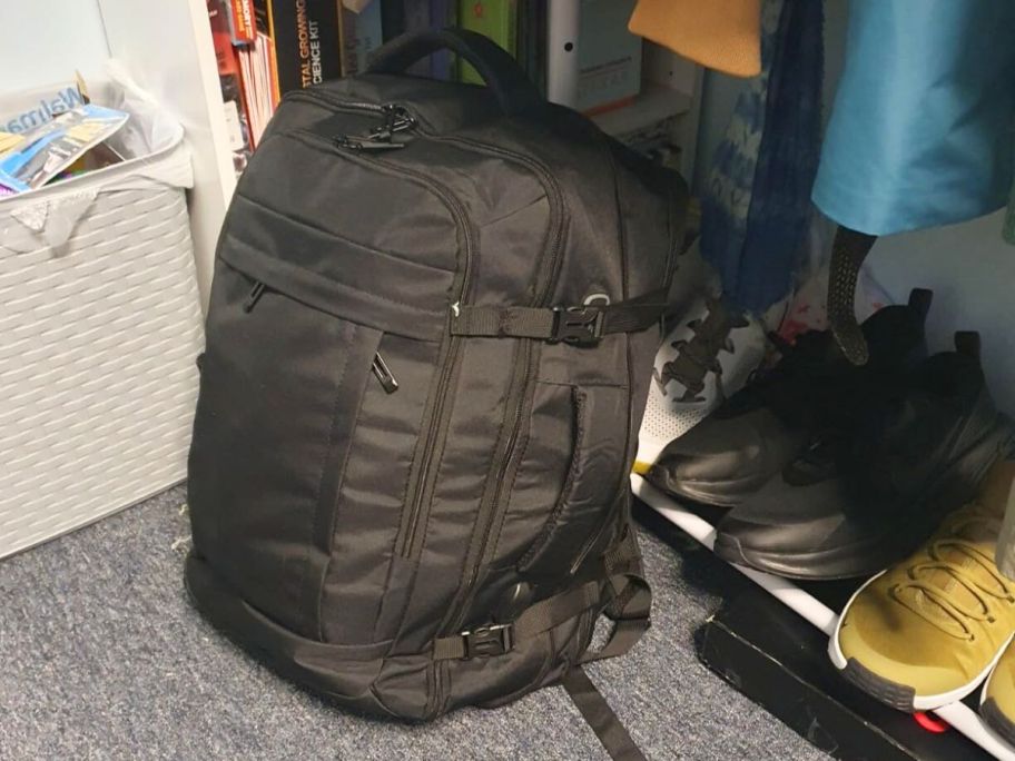 black travel backpack on floor in closet