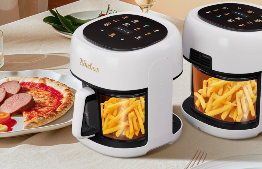 white glass air fryers with french fries sitting on kitchen counter