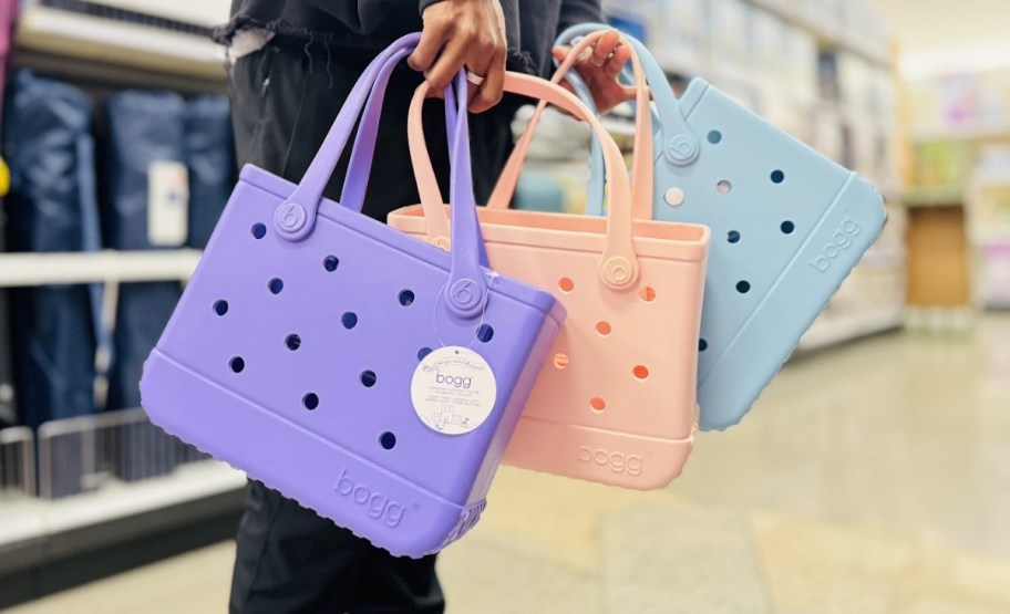 a womans hands holding 3 bitty bogg bags