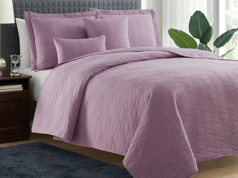 purple comforter and pillows on bed