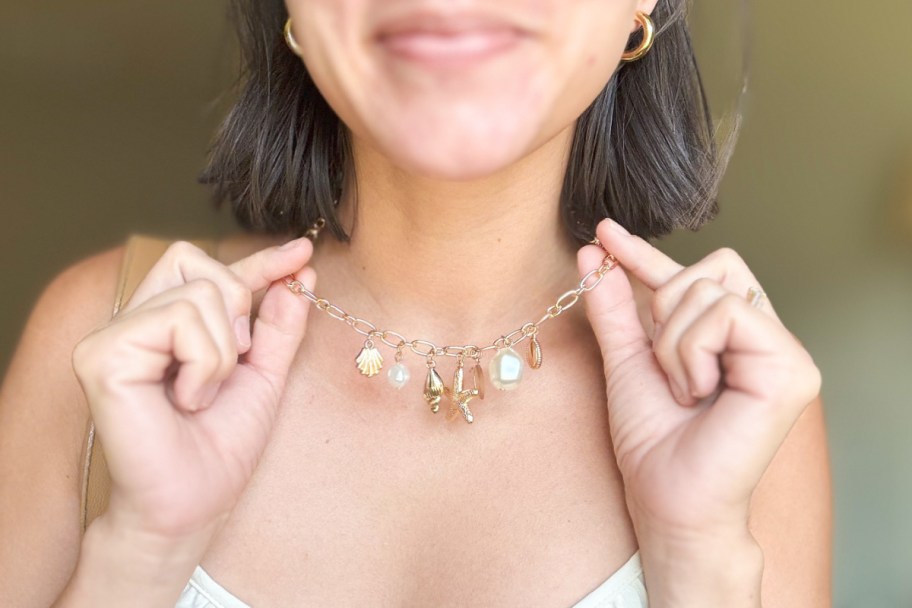 woman holding starfish necklace around neck