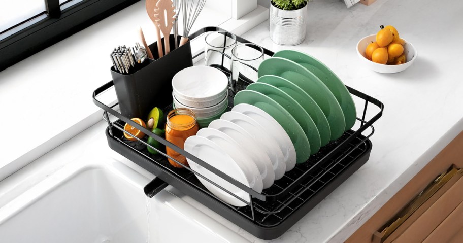 dish rack filled with dishes next to a kitchen sink