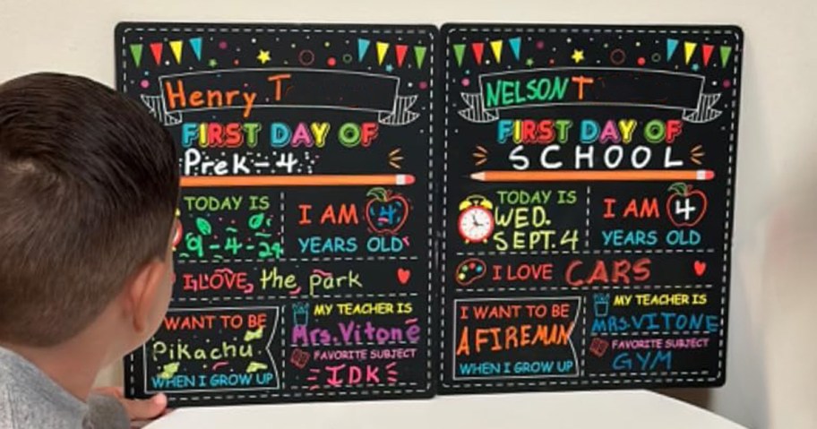 child looking at first day of school chalkboard sign