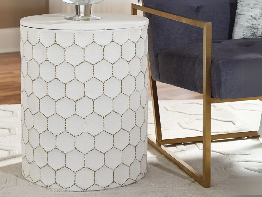 white Signature Design by Ashley Polly Geometric Honeycomb Stool next to chair