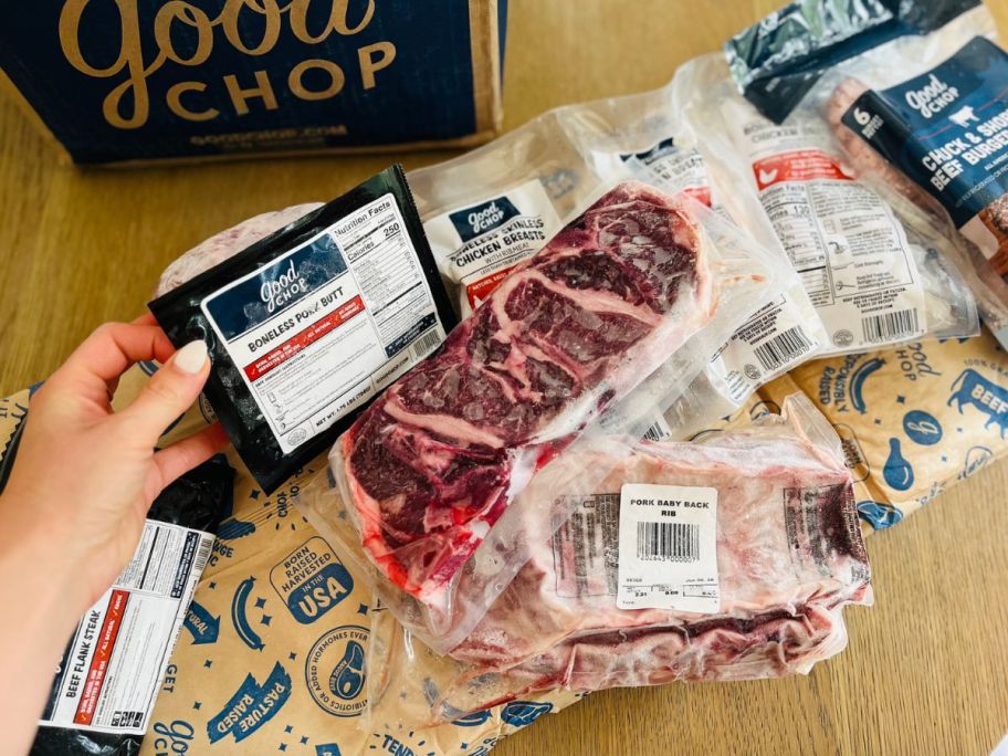 hand holding meat from a good chop order with other meats displayed