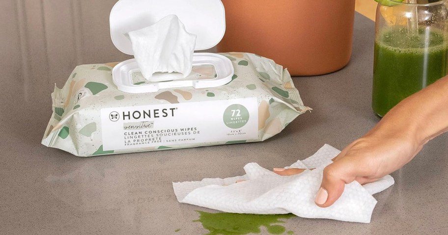 honest wipes bag on table with someone cleaning spill with wipe 