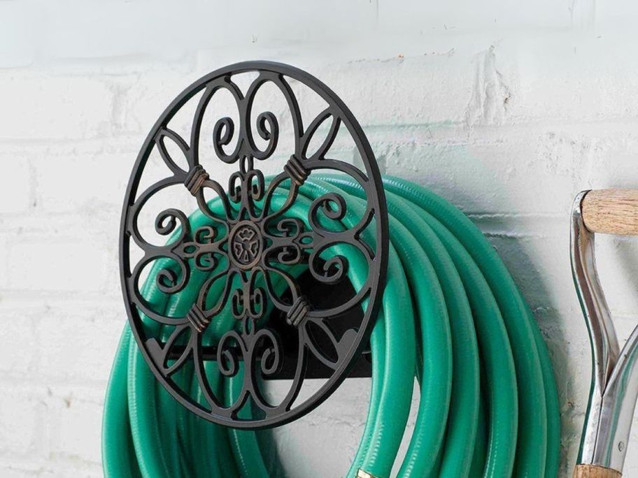 decorative hose hanger holding hose on the side of house