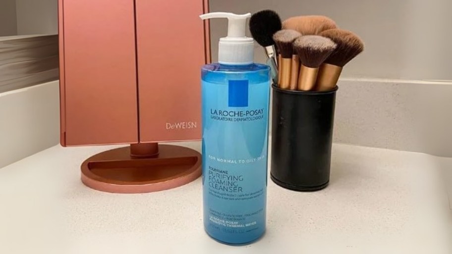a bottle of facial cleanser sitting on a bathroom counter