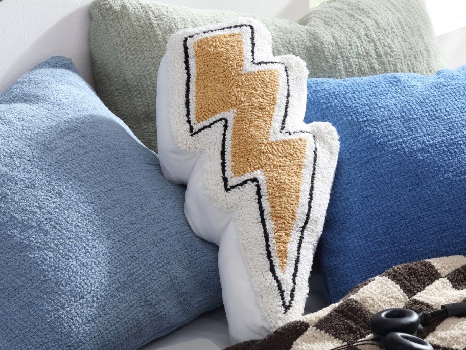 lightning bolt pillow on a bed with other pillows