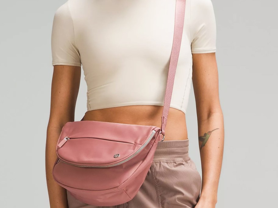 woman in a white top with a large pink crossbody bag