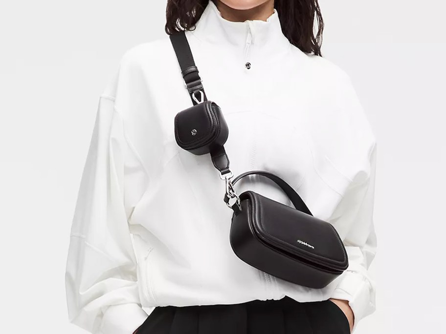 woman in a white sweatshirt with a black crossbody bag