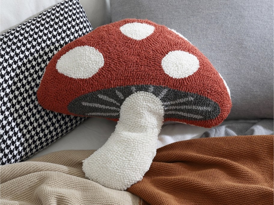 a mushroom pillow on a bed with other pillows