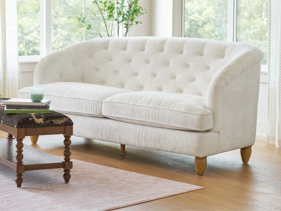 a white tufted sofa in a living room