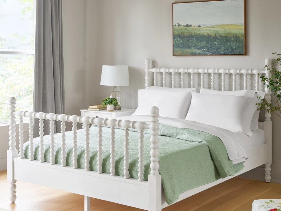a white wood spindle bed in a bedroom