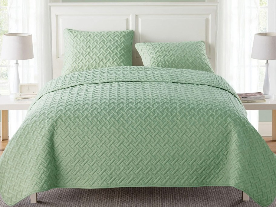green comforter and pillows on bed 