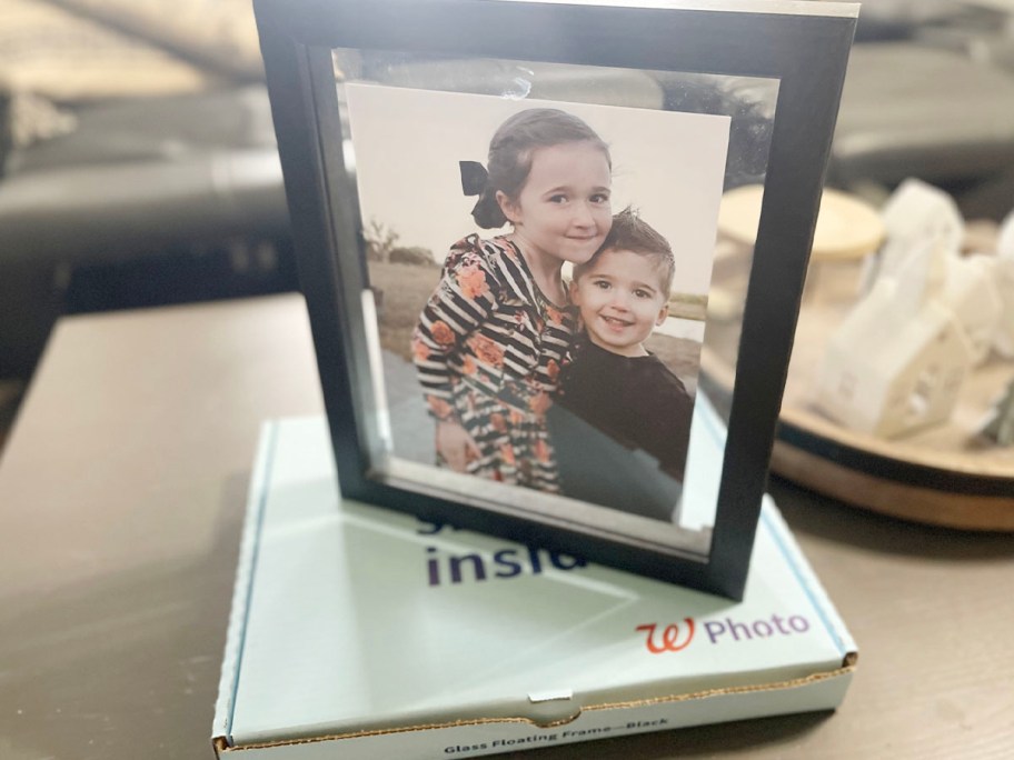 picture of two kids in floating frame on box on table