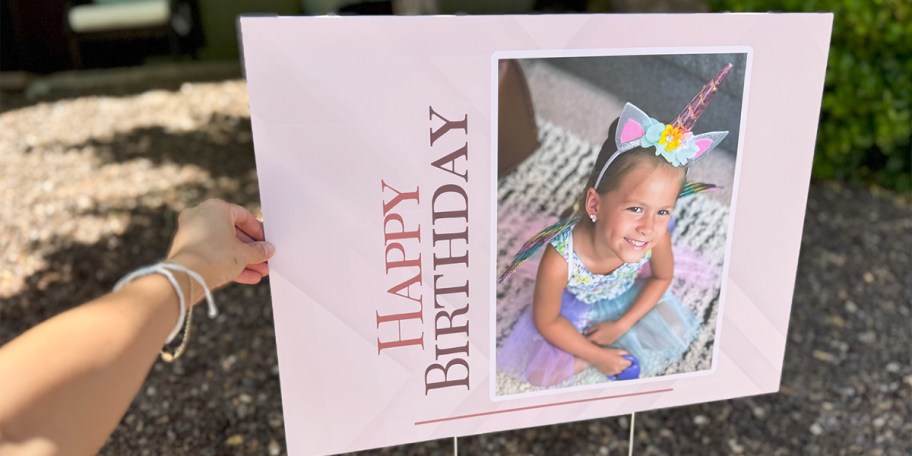 hand reaching for pink happy birthday sign 