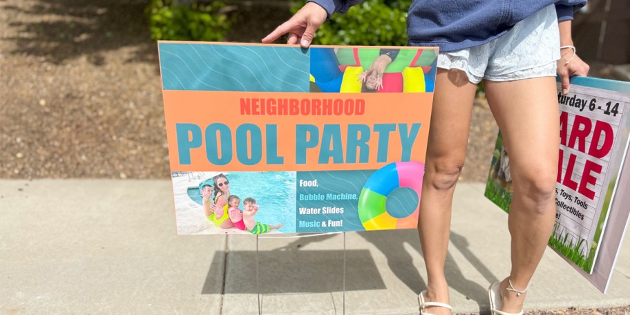 woman standing next to pool party yard sign 