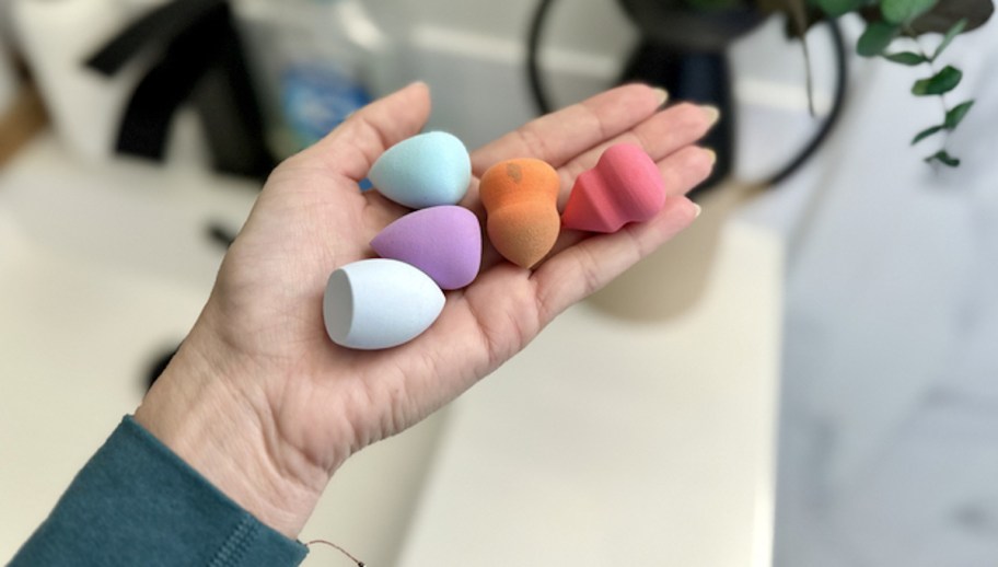 hand holding pile of beauty blenders