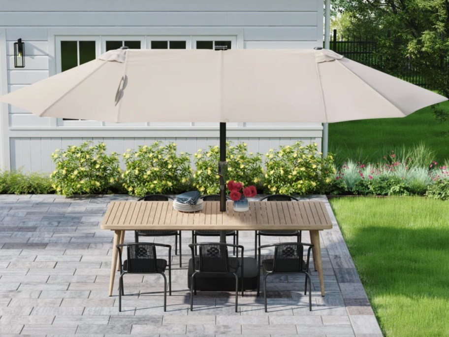 triple wide tan umbrella over table